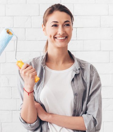 young-woman-holding-paint-roller-for-renovation-at-YVK8WJV-p7eedmlu5rr9cs51xw7woxl1fedlnpq761jdst1iks